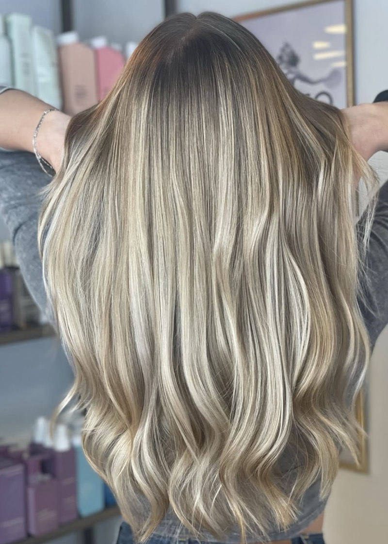 Langt blondt hår med lyse highlights og bløde bølger, set bagfra
